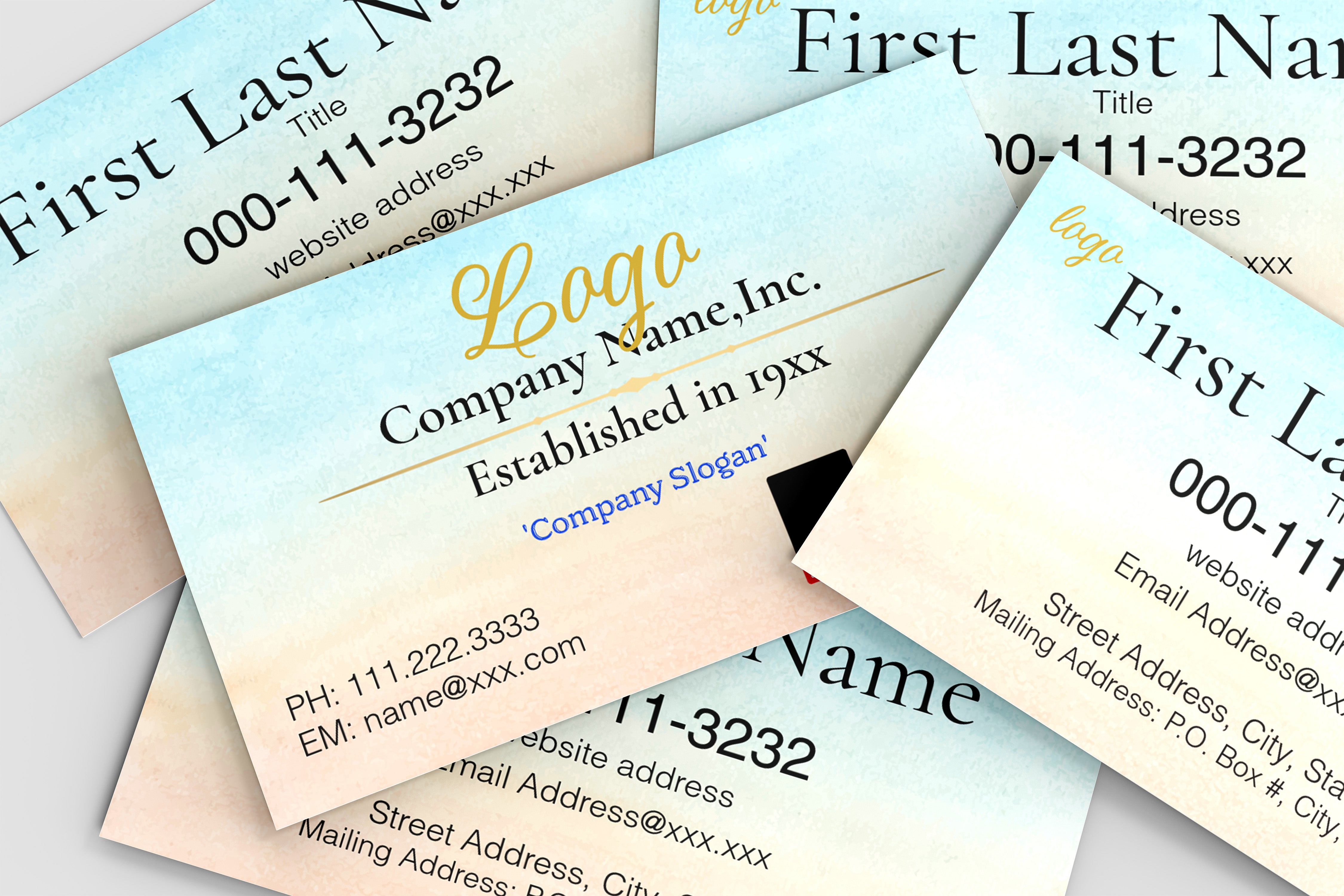 A close-up, angled view of several business cards fanned out. The cards have a soft watercolor gradient background transitioning from pale blue at the top to warm beige at the bottom.