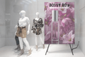 Mannequins in a store window with a BOSSY RO's perfume display.