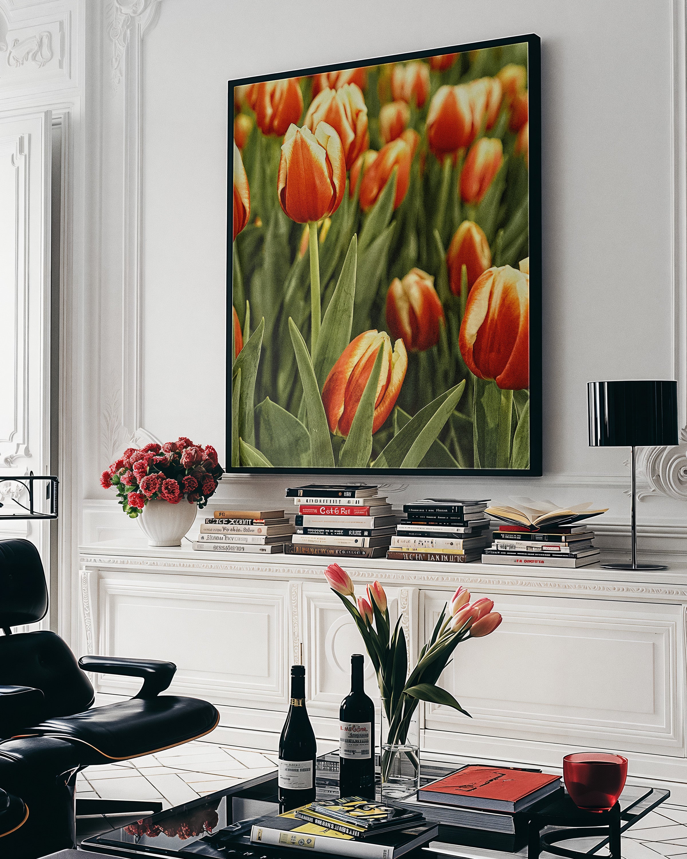 A large framed wall art print depicting a field of orange-red tulips with green stems, displayed in a modern living room setting above a console table with books and decor.