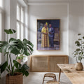 A framed portrait print hangs on a white wall above a light wood cabinet in a bright, modern room with large potted plants and a wooden table.