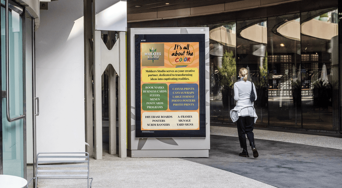 Person walking past a digital display with colorful text in an urban setting