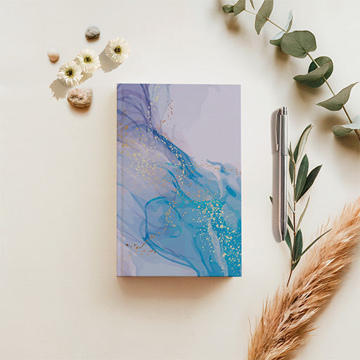 Purple-Blue Artist Series journal with flowing turquoise-blue and lavender abstract artwork and gold-inspired accents, displayed with botanical styling.