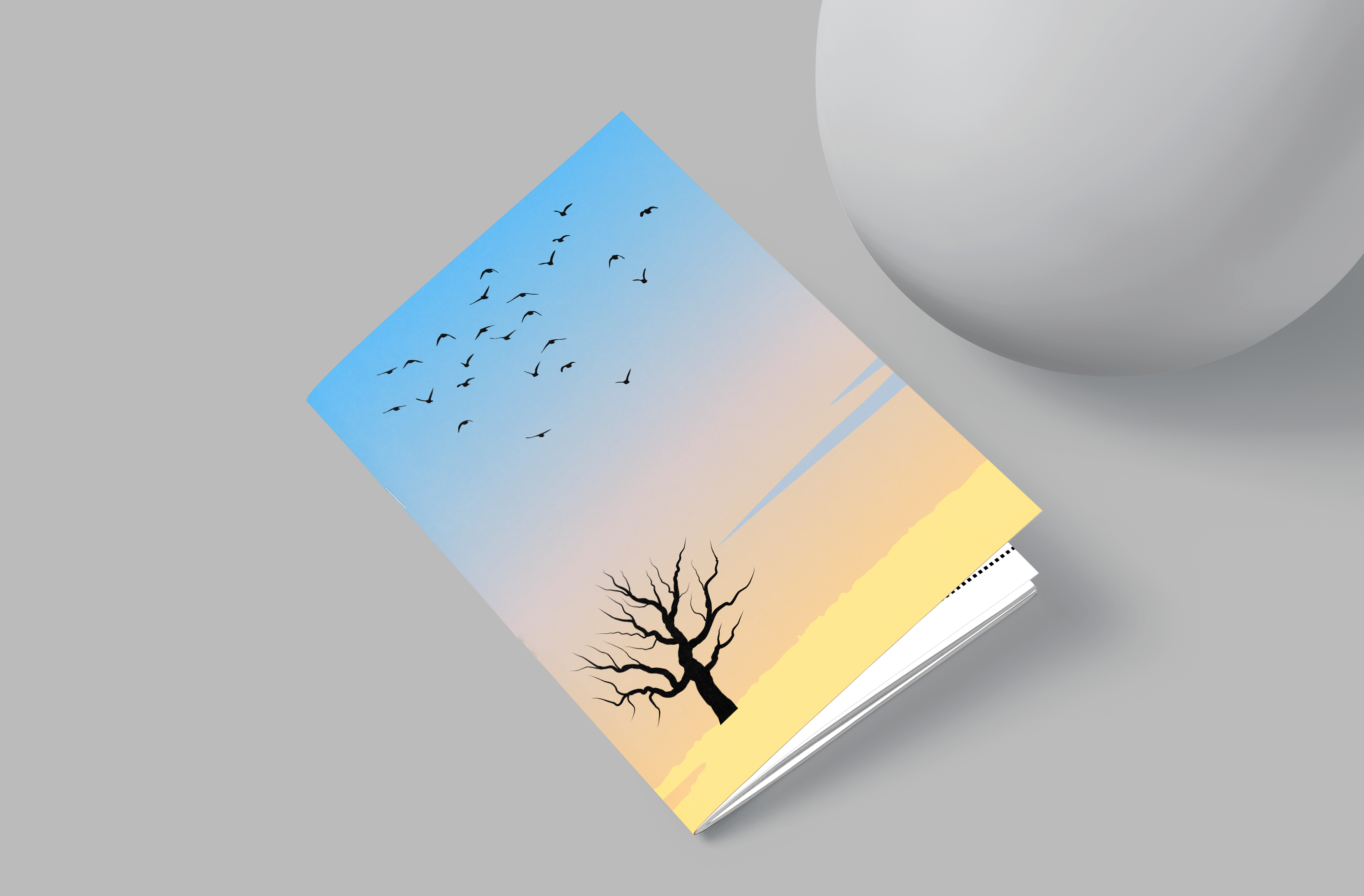 Book with a cover design of a tree and birds on a gradient background, placed on a gray surface.