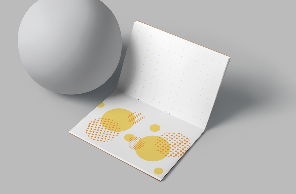 White paper with yellow circular patterns on a gray surface interior of a notebook. 