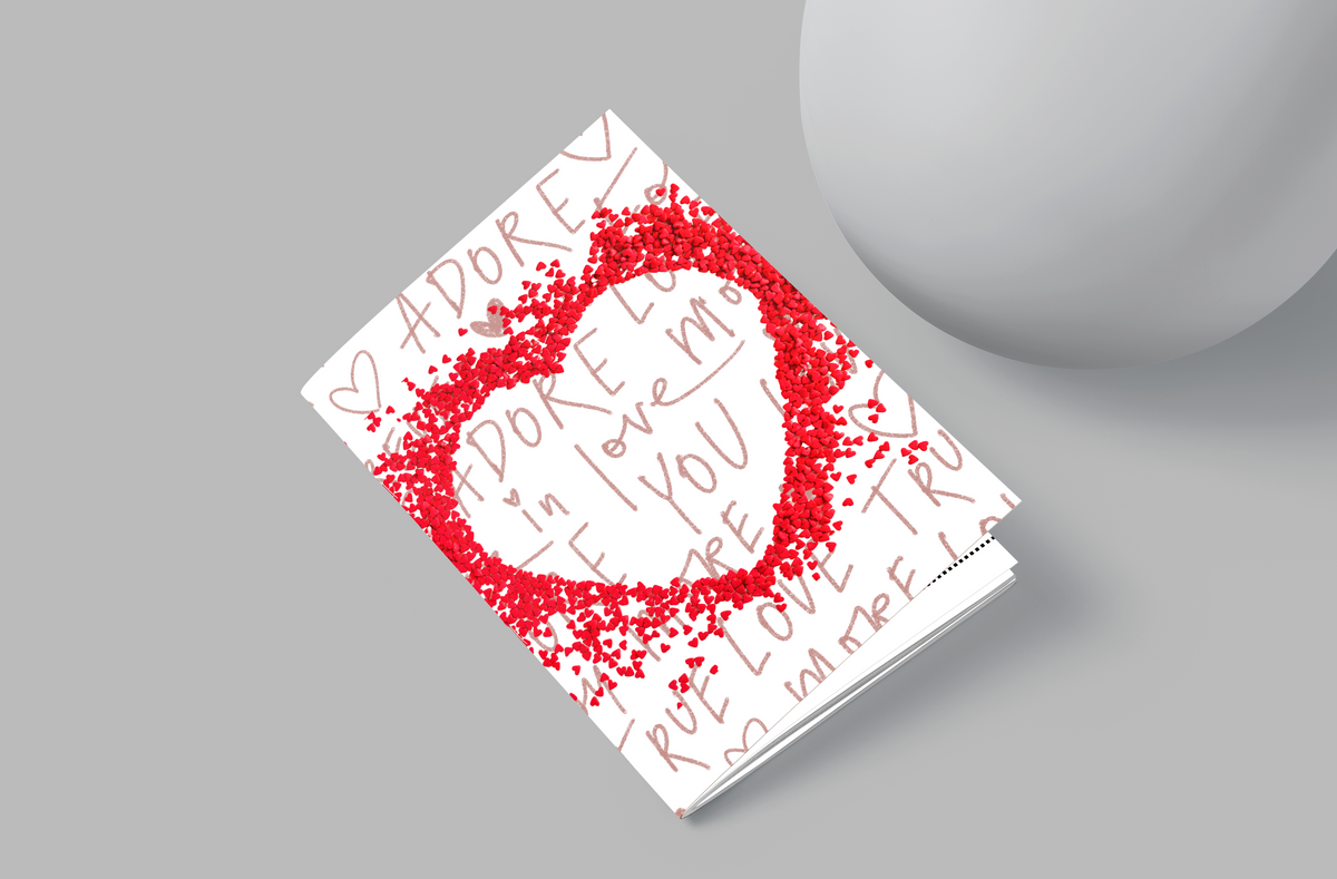 Notebook with red heart design and text on a gray background