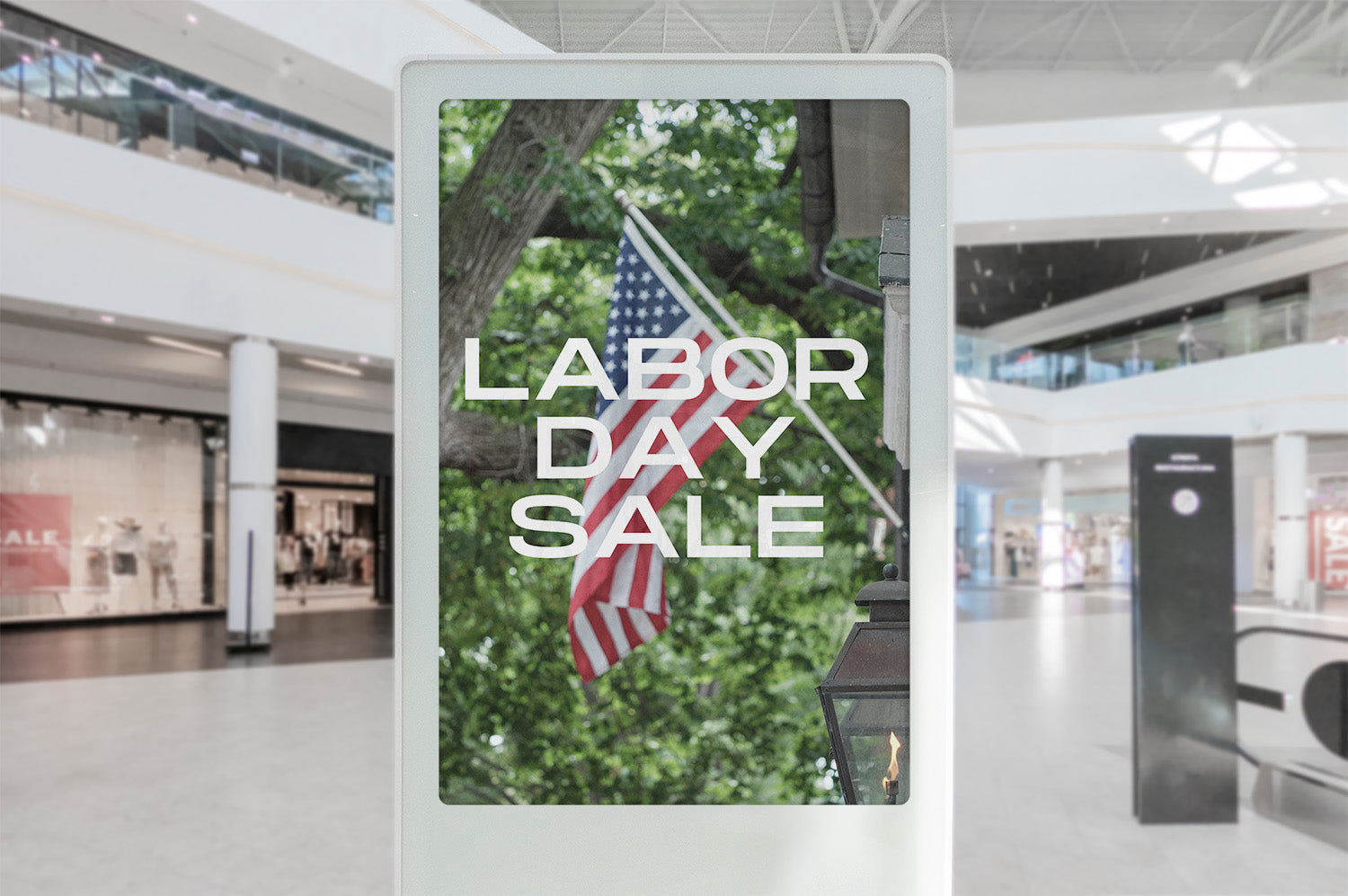 Digital display in a store with 'Labor Day Sale' text and American flag.
