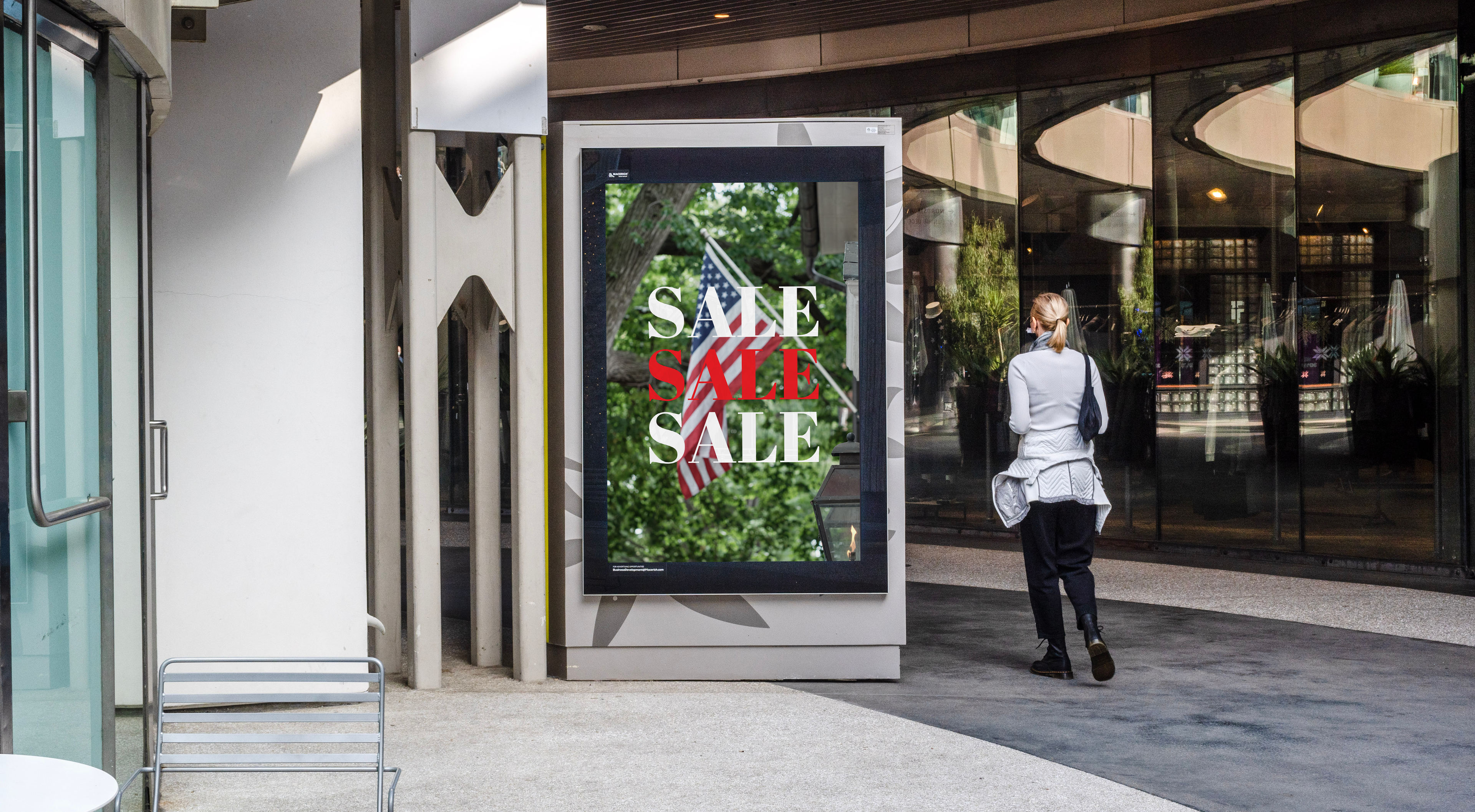 Digital display with 'SALE' text in a modern building entrance